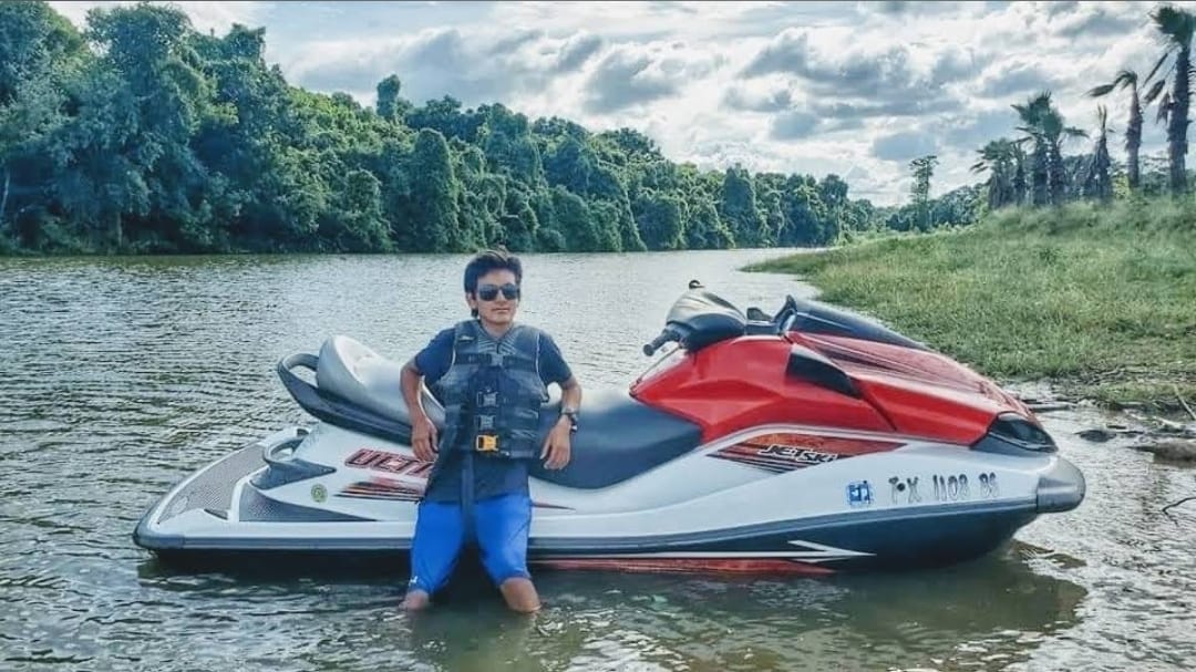 Boy leaning on jet ski